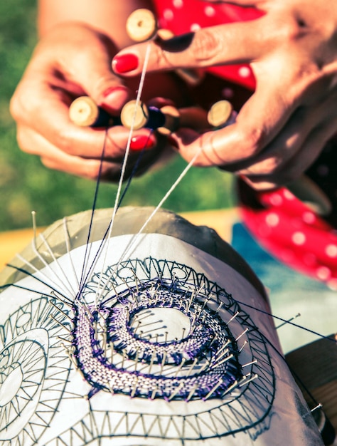 Mani del modello di ricamo di cucito della donna