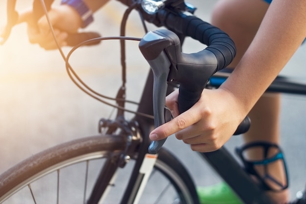 mani del primo piano e manubrio di un giovane motociclista in strada