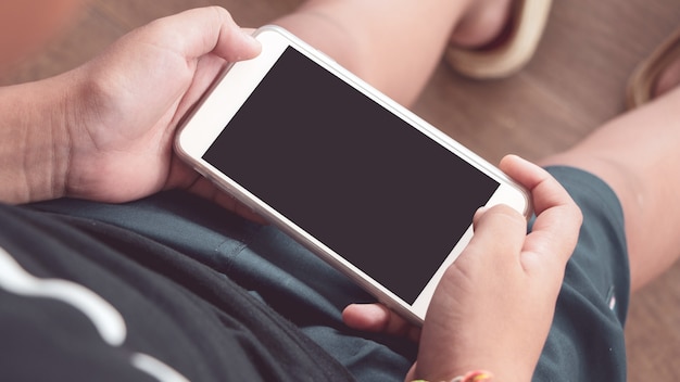 Mani del ragazzo che tiene smartphone in mano con schermo nero