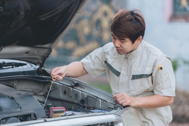 Mani del riparatore del meccanico di automobile che riparano un'officina automobilistica del motore dell'automobile