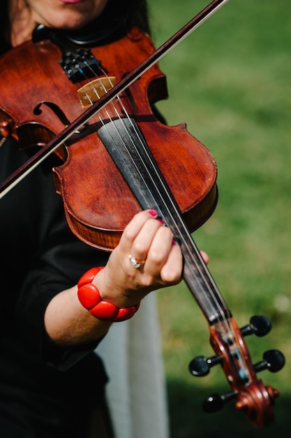 Mani del violinista Violinista che suona il violino sullo sfondo del campo Performance sulla natura Primo piano di strumenti musicali Musica classica violoncellista professionista solista Persona irriconoscibile
