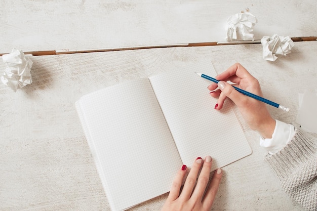 Mani dell'artista che disegnano nello spazio libero del quaderno in bianco