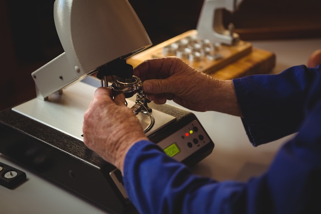 Mani dell'orologista che riparano un orologio