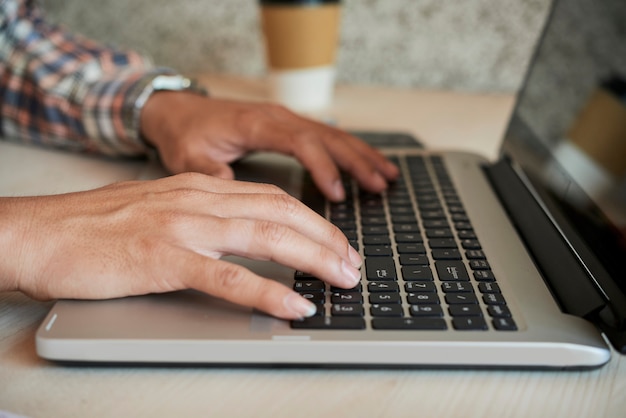 Mani dell'uomo che lavorano al computer portatile