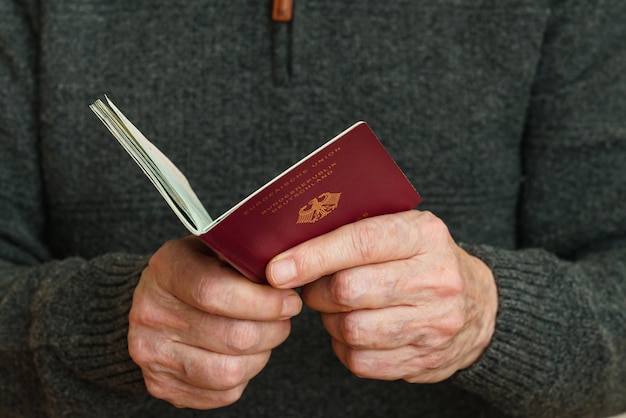 Mani dell'uomo che tengono un passaporto biometrico tedesco aperto