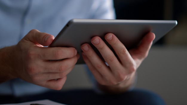 Mani dell'uomo d'affari che utilizzano il computer tablet navigando in internet in ufficio a casa Amministratore delegato irriconoscibile seduto tenendo in mano un dispositivo digitale navigando sui social media nel posto di lavoro remoto Concetto di lavoro tecnologico aziendale