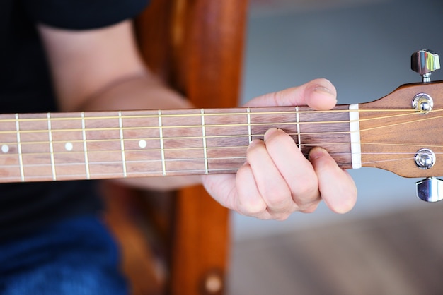 Mani dell'uomo suonare la chitarra acustica, close up chitarrista Strumento musicale Hobby domestici