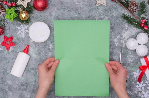 Mani della donna che fanno una decorazione del mestiere di Natale