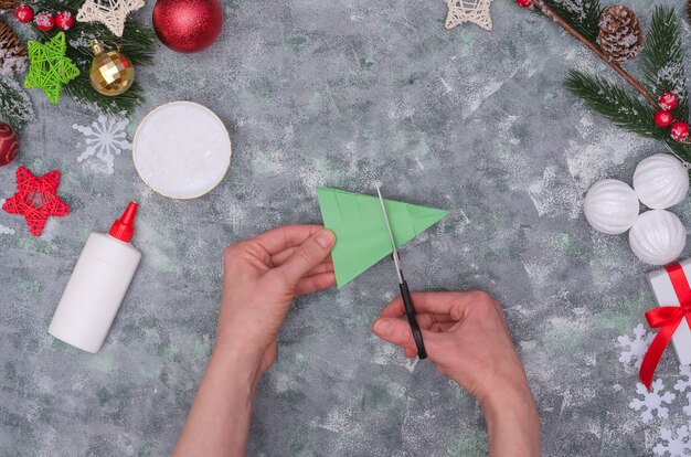 Mani della donna che fanno una decorazione del mestiere di Natale