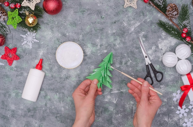 Mani della donna che fanno una decorazione del mestiere di Natale