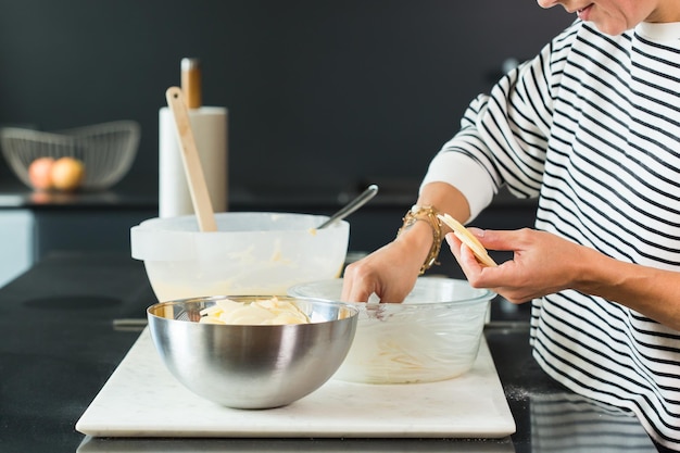 Mani della donna che mettono le mele durante la cottura della torta di mele