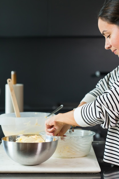 Mani della donna che mettono le mele durante la cottura della torta di mele