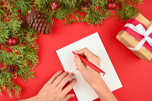 Mani della donna che scrivono una lettera per il Natale