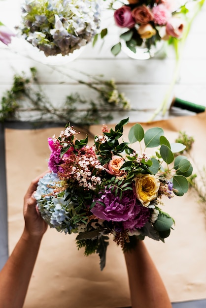 Mani della donna che tengono il mazzo di bei fiori