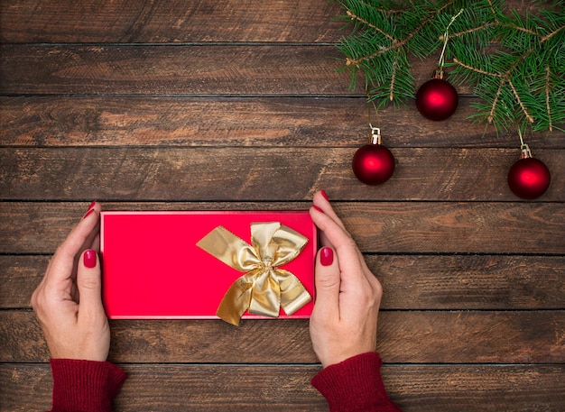 Mani della donna che tengono regalo di Natale