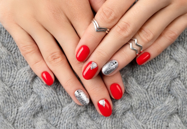 Mani della donna con il manicure rosso alla moda.