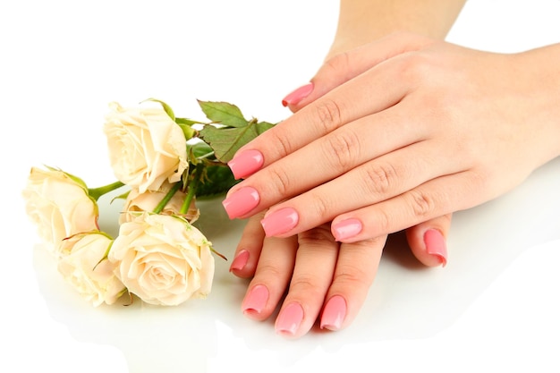Mani della donna con manicure rosa e fiori isolati su bianco