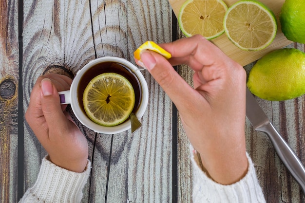 Mani della donna con una tazza di tè