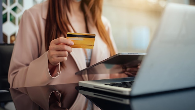 Mani della donna d'affari che usano lo smartphone e tengono la carta di credito seduta Shopping online conceptxAxA