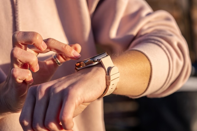 Mani della donna in un orologio intelligente che cammina all'aperto, conteggio dei passi, fitness tracker, primo piano, spazio di copia