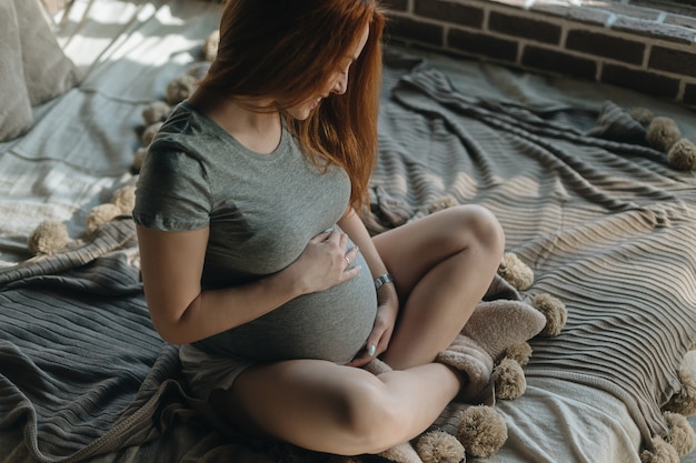 Mani della donna incinta che abbracciano pancia in attesa