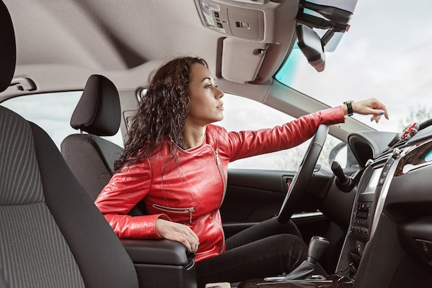 Mani della donna sul volante dell'auto.