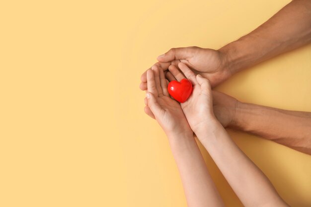 Mani della famiglia con cuore sul colore