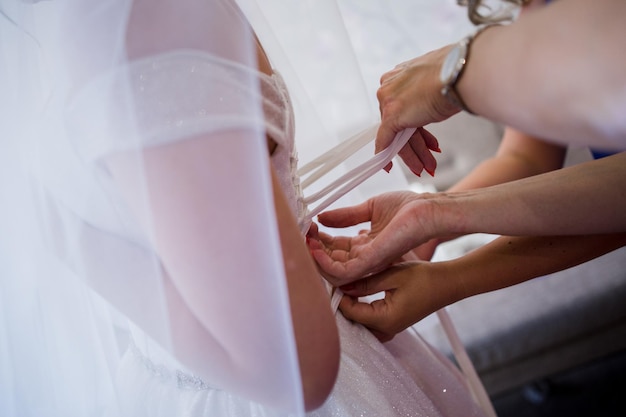 Mani della sposa su un abito da sposa