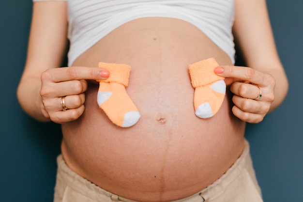 Mani delle donne che tengono calze bambino