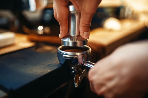 Mani di barista maschio, preparazione di caffè nero fresco