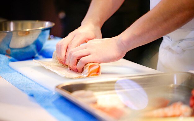 mani di cuoco che preparano cibo giapponese cuoco che fa sushi che prepara Maki Sushi roll