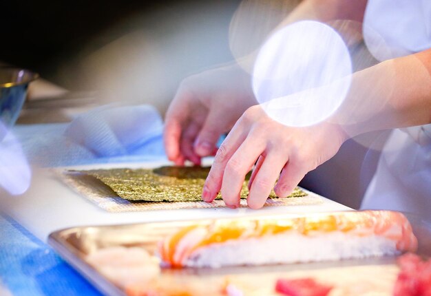 mani di cuoco che preparano cibo giapponese cuoco che fa sushi che prepara Maki Sushi roll