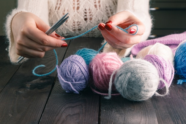 Mani di donna a maglia con ferri da maglia alla moda