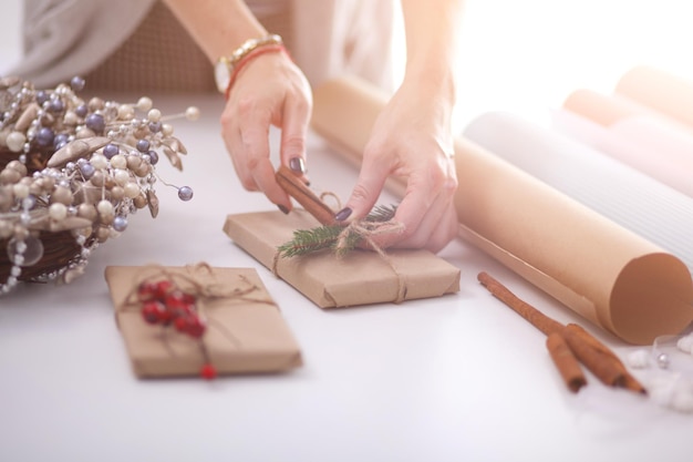 Mani di donna che decorano confezione regalo di Natale Mani di donna