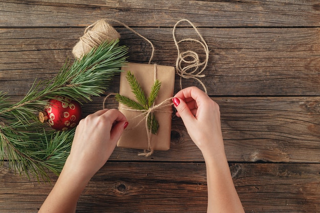 Mani di donna che decorano la scatola dei regali di Natale