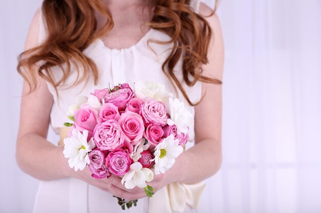 Mani di donna che tengono bel bouquet da sposa