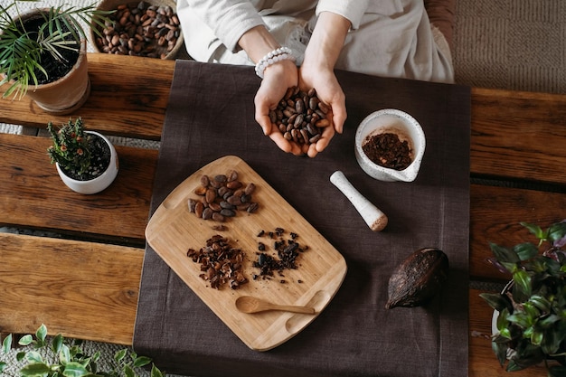 Mani di donna che tengono le fave di cacao biologico per la cerimonia