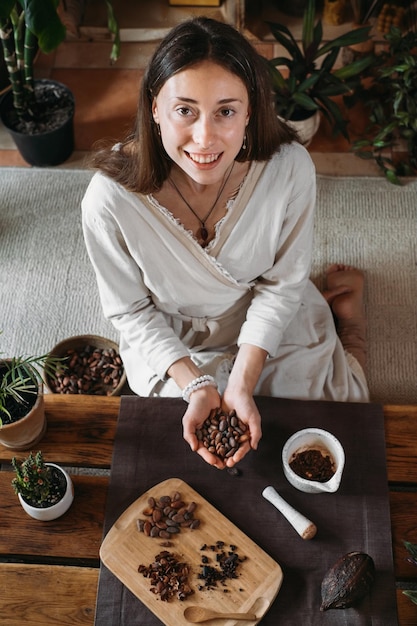 Mani di donna che tengono le fave di cacao biologico per la cerimonia