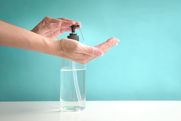 Mani di donna che utilizzano un erogatore a pompa di disinfettante per le mani liquido