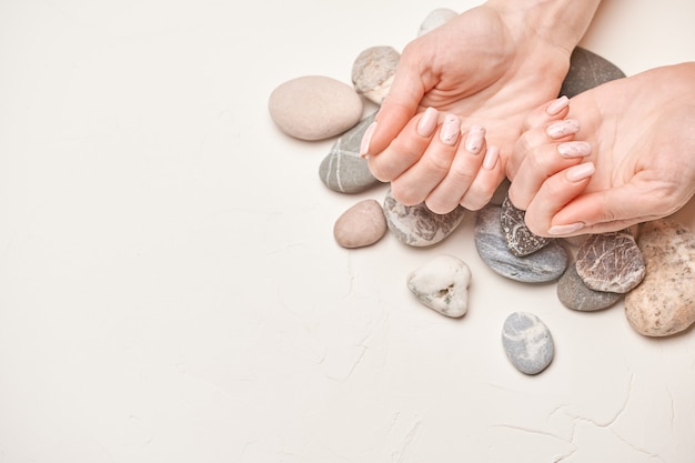 Mani di donna con bella manicure su sfondo chiaro light