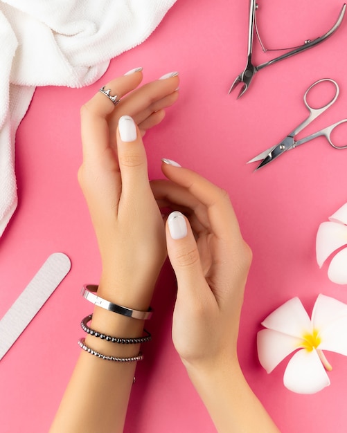 Mani di donna con french manicure alla moda bianca