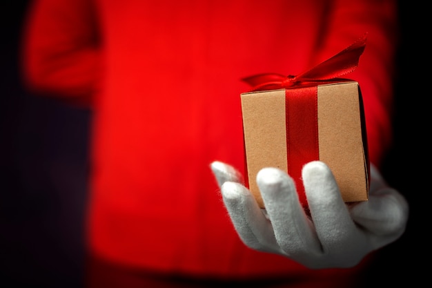 Mani di donna con guanti bianchi con scatole regalo