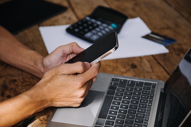 Mani di donna d'affari che tiene in mano una carta di credito e utilizza la carta di credito per fare acquisti online