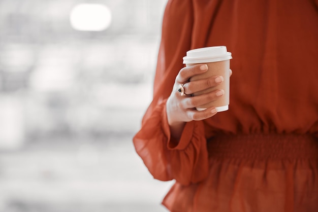 Mani di donna d'affari o tazza di caffè usa e getta con spazio mockup nella caffetteria dell'ufficio Primo piano del lavoratore con contenitore di carta per bere cappuccino espresso da asporto o bevanda al latte per l'energia