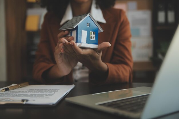 Mani di donna femminile che tengono casa modello piccolo giocattolo bianco in miniatura casa Assicurazione proprietà ipotecaria sogno casa mobile e concetto immobiliare