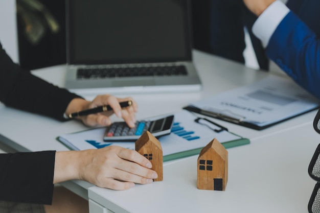 Mani di donna femminile che tengono il modello di casa piccola casa giocattolo bianca in miniatura Assicurazione sulla proprietà ipotecaria sogno trasloco e concetto immobiliare