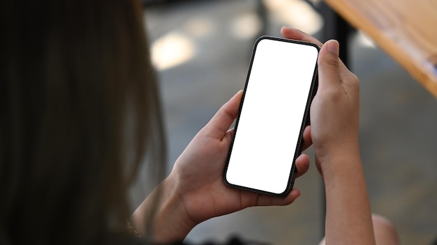 Mani di donna in possesso di smartphone con schermo vuoto bianco per la pubblicità