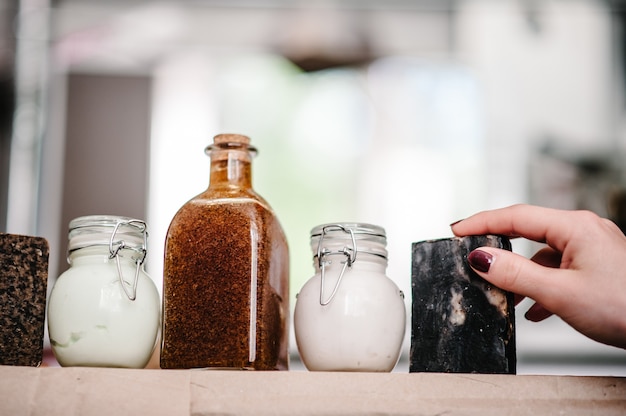 Mani di donna prende il sapone dallo scaffale, prodotti cosmetici