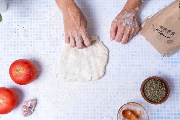 Mani di donne che allungano una pasta di farina