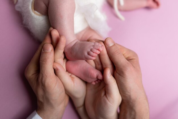 mani di genitori e figli. gambe di un neonato nelle mani di mamma e papà. le gambe del bambino nelle mani.